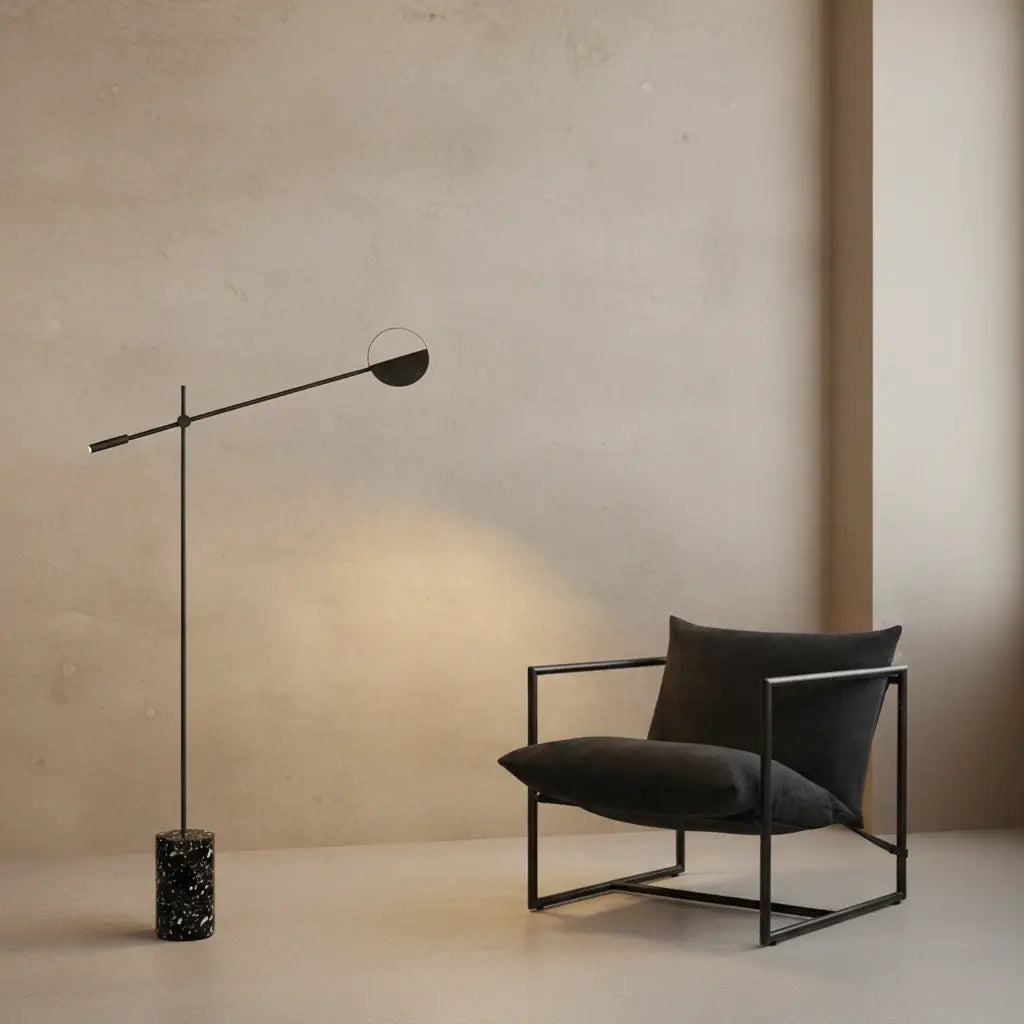 Petal Poise Floor Lamp featuring black frame and black terrazzo cylindrical base positioned beside modern lounge chair,a Domus Collective sculptural floor lighting for refined minimal-inspired spaces.