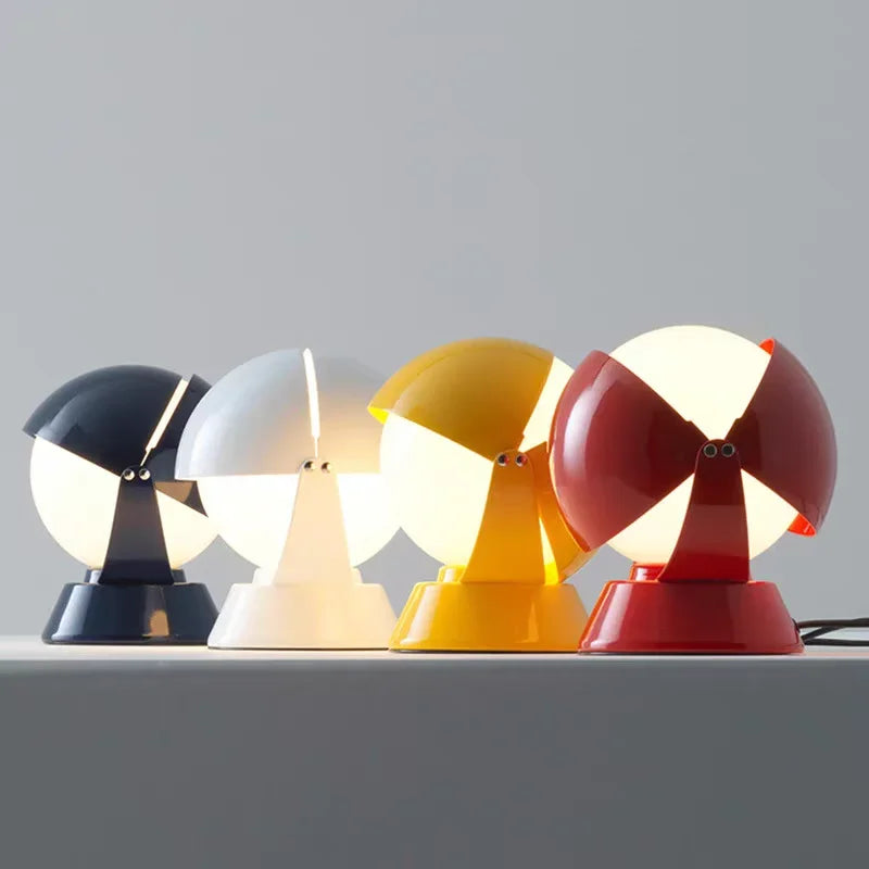 Bold pop-art inspired PikaGlow Table Lamps in navy, white, yellow, and red glossy lacquer, featuring retro-modern spherical forms with frosted glass diffusers for inviting illumination, by Domus Collective.