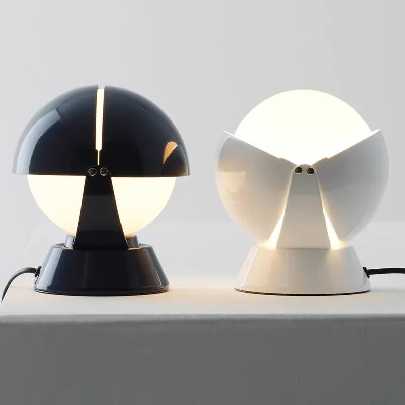 Sophisticated PikaGlow Table Lamps in charcoal navy and crisp white glossy finishes, their adjustable sculptural globes revealing frosted inner spheres that glow with warmth, by Domus Collective.