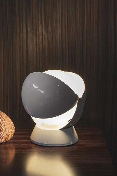 Intimate styling with the PikaGlow Table Lamp in grey lacquer, its whimsical character design creating a soft ambient glow against rich wood grain textures for modern living spaces.