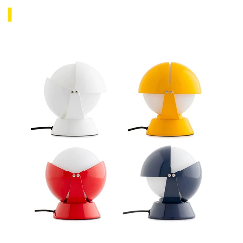 Four PikaGlow Table Lamps displayed in white, yellow, red, and navy lacquered finishes, each featuring the signature rotating globe design with frosted diffuser for joyful modern interiors.