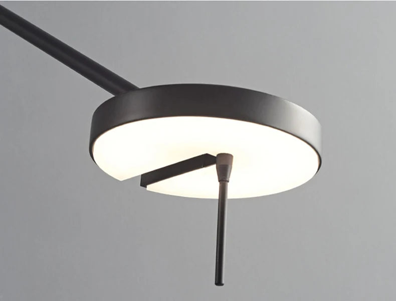 Full extension view of the Refined Span Wall Light displaying the warm-toned LED disc head, precision pivot joint, and circular wall mount in sophisticated black metal finish.