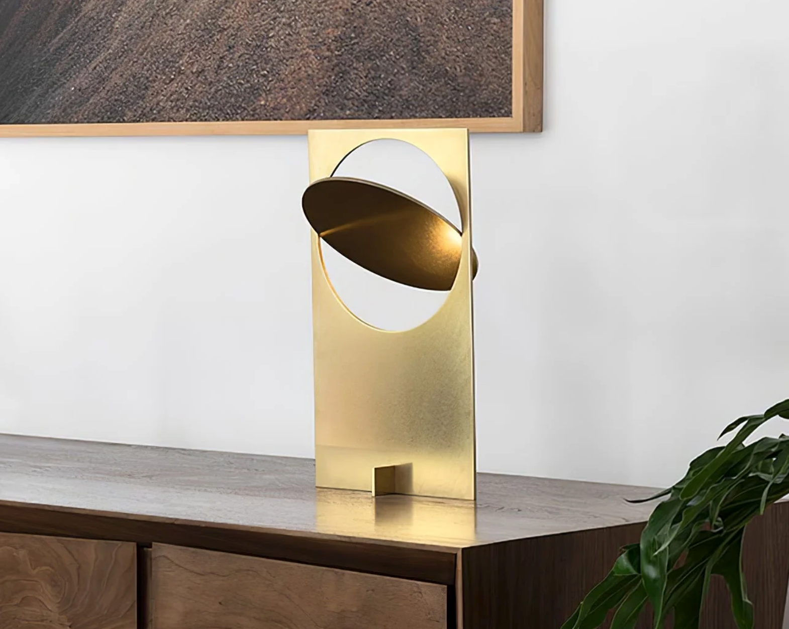 Riflesso Table Lamp in polished Titanium Gold with adjustable reflective blade angled within geometric frame, bringing luxurious warmth to contemporary credenzas by Domus Collective.