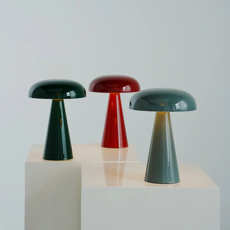 Shroom Aura Portable Lamps in glossy forest green, red, and grey finishes displayed together, showcasing the playful mushroom silhouette and polished metal construction by Domus Collective.