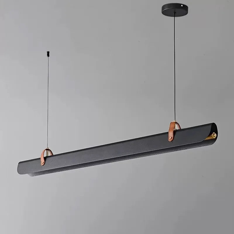 Sleek scroll pendant light by Domus Collective with a dark gray fixture and copper accents on a gray background