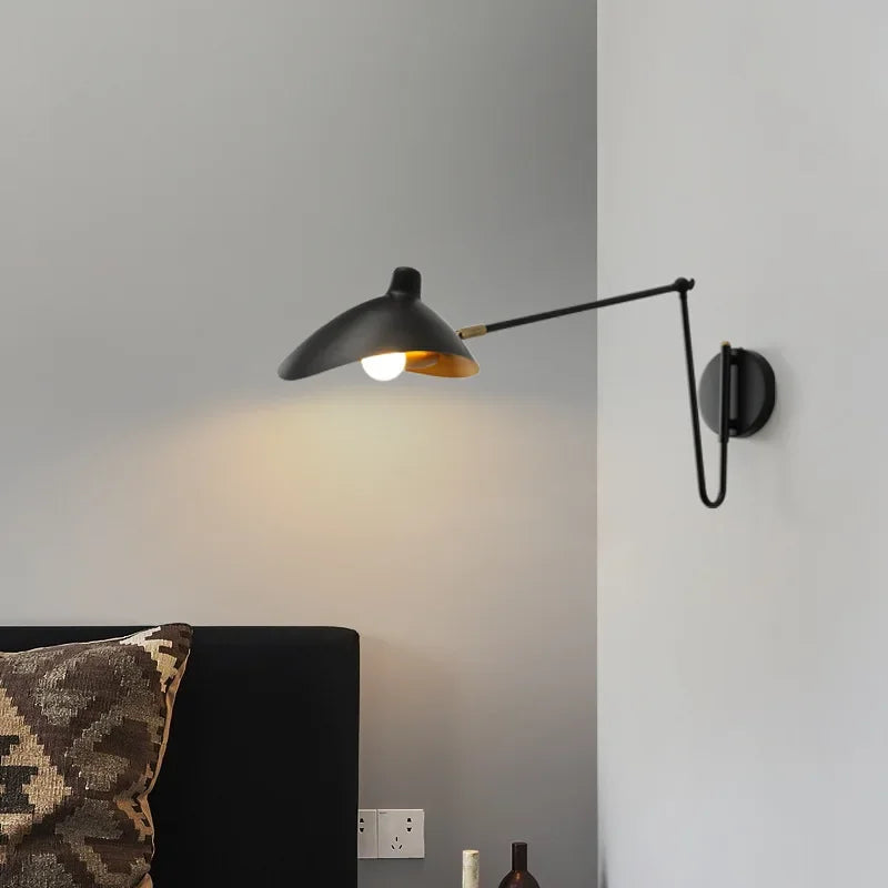 Matte black Solar Beam Wall Lamp with extended swing arm and organic curved shade, artisan wall light casting warm directional glow for modern reading corners, by Domus Collective.