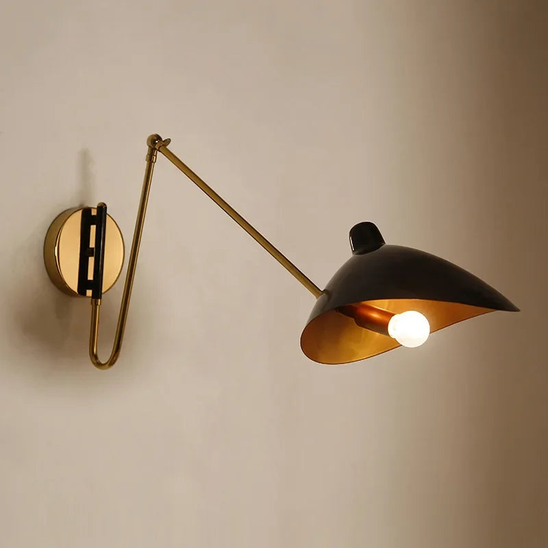 Solar Beam Wall Lamp featuring black shade with golden interior and polished brass mounting hardware, handcrafted adjustable sconce blending sculptural drama with refined sophistication, by Domus Collective.