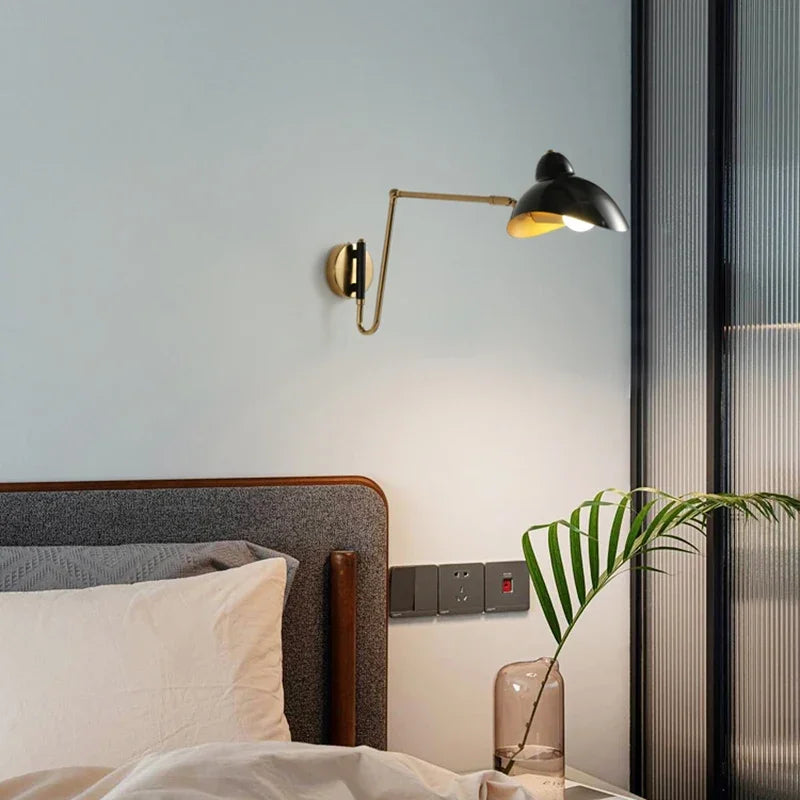 Black and brass Solar Beam Wall Lamp mounted as bedside reading light, curated swing arm sconce bringing celestial warmth to serene modern bedroom interiors, by Domus Collective.