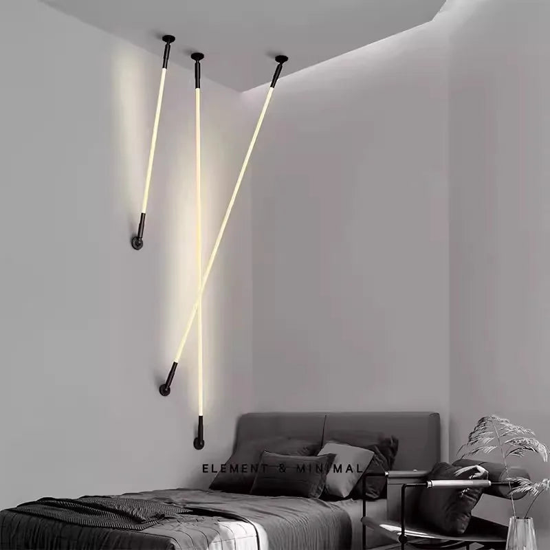 Three Spectra Flex Wall Lights with bendable illuminated tubes and black hardware creating dynamic intersecting lines across a bedroom corner, delivering artistic flexibility for contemporary interior lighting, by Domus Collective.