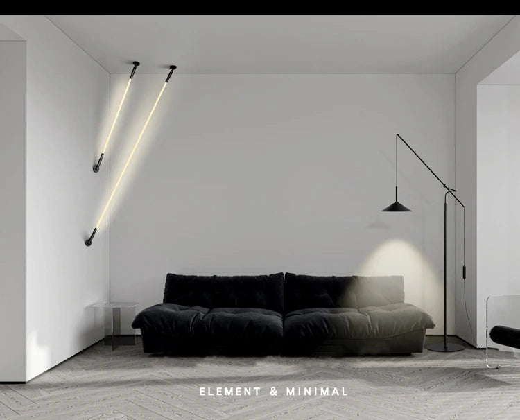 Pair of Spectra Flex Wall Lights in parallel diagonal arrangement casting warm ambient glow above a contemporary charcoal sofa, their sleek linear forms complementing minimalist living room design, by Domus Collective.