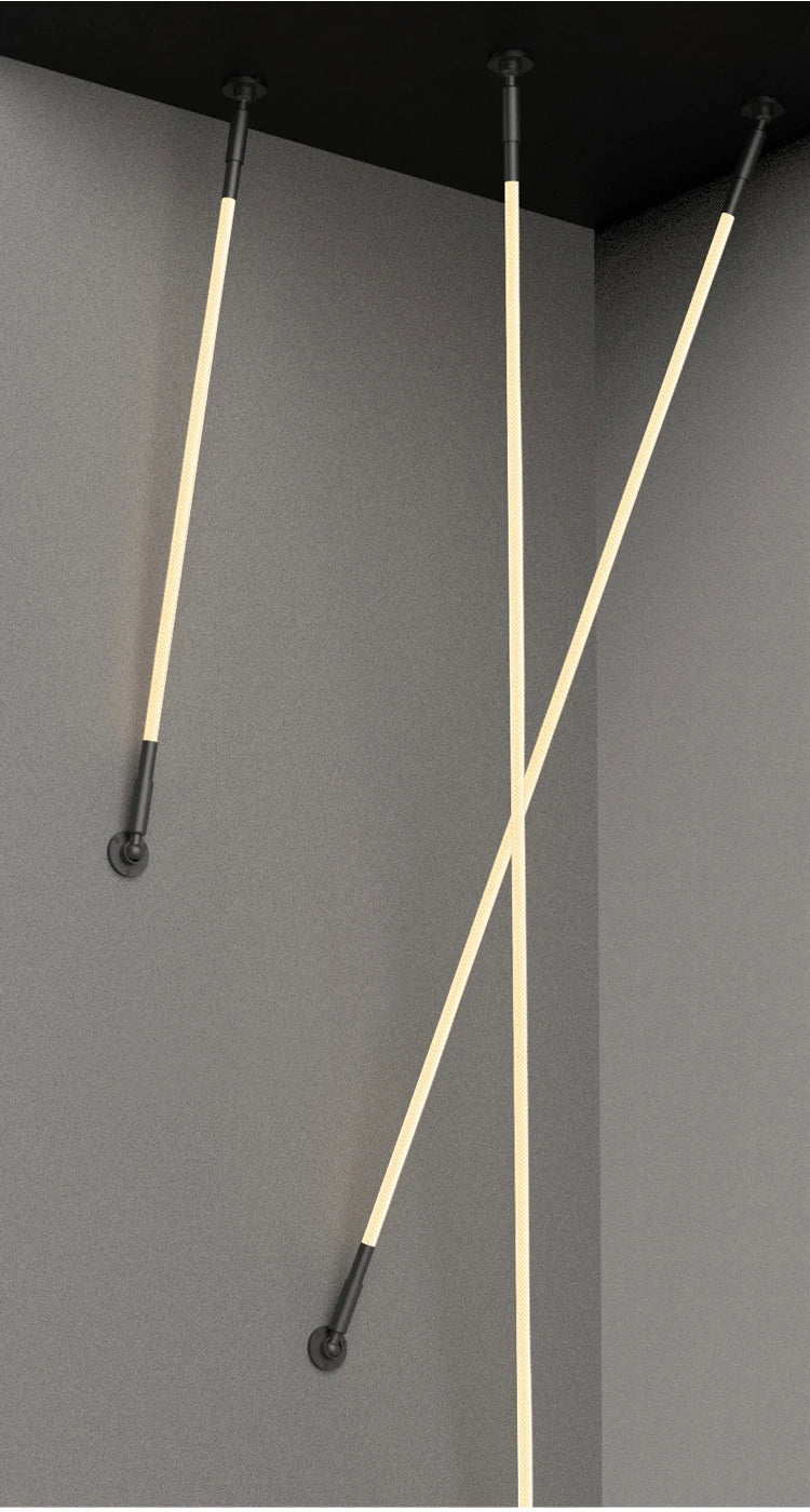 Spectra Flex Wall Lights with warm LED tubes mounted between ceiling and wall in intersecting angles, showcasing the dynamic sculptural possibilities and matte black hardware against grey surfaces, by Domus Collective.