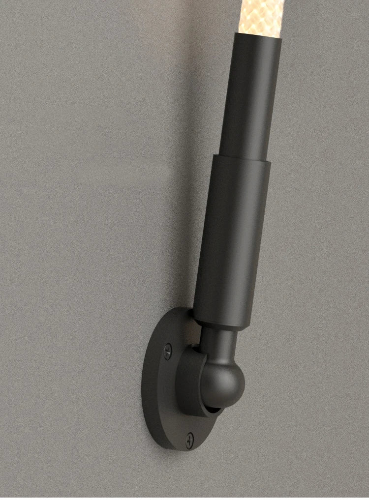 Detail view of the Spectra Flex Wall Light's matte black ball-joint mounting bracket and cylindrical hardware, demonstrating the articulating design that enables flexible positioning and creative configurations, by Domus Collective.