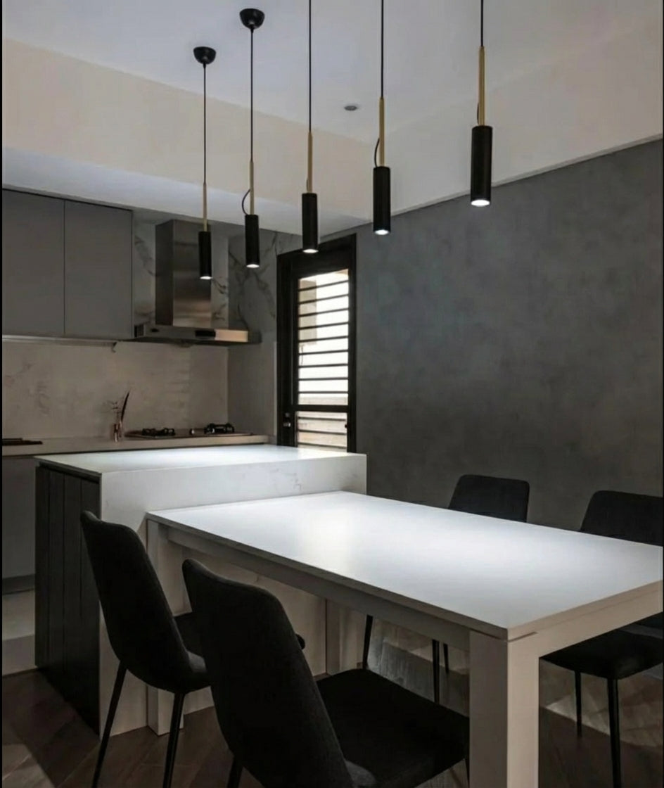 Domus Collective Spotlight Pendant Lights in black, clustered at varying heights above a monochrome kitchen and dining space,focused beams of light anchoring a sleek contemporary Australian interior.