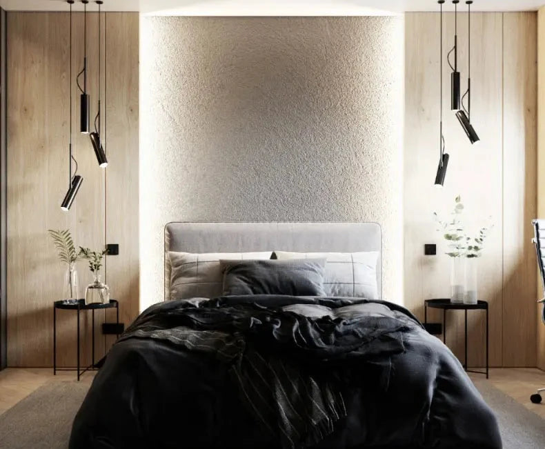 Clusters of black Spotlight Pendant Lights from Domus Collective flanking a dramatic bedroom feature wall, their angled beams framing a textured bedhead with cinematic precision.