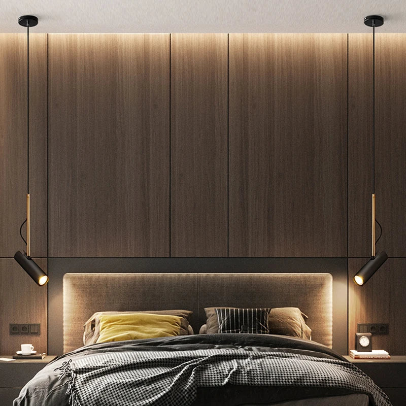 Domus Collective Spotlight Pendant Light in black-gold, a symmetrical pair suspended over a warm timber bedroom setting, timeless directional lighting that elevates the everyday into something considered.