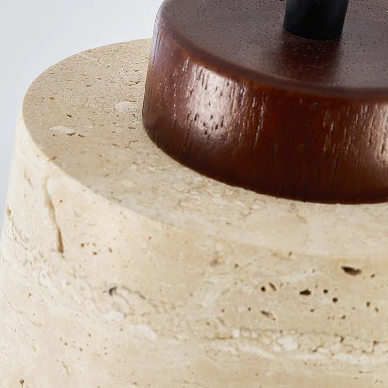 Artisanal detail of polished walnut wood cap meeting raw travertine stone in the Stone Cylinder Pendant Lamp, showcasing handcrafted quality and natural material harmony, by Domus Collective.