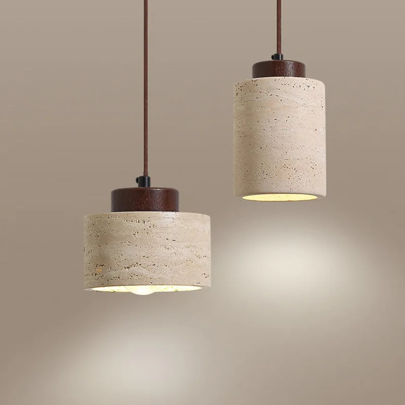 Walnut Stone Cylinder Pendant Lamps in two Tall silhouettes showcasing natural travertine grain and rich wood detailing, offering artisanal craftsmanship and gentle ambient illumination, by Domus Collective.
