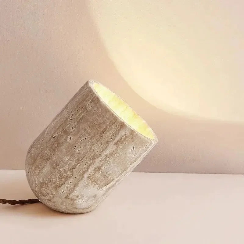 Close-up of the Stone Spotlight Table Lamp revealing distinctive travertine texture and porous surface, angled design creating intimate directional lighting, by Domus Collective.