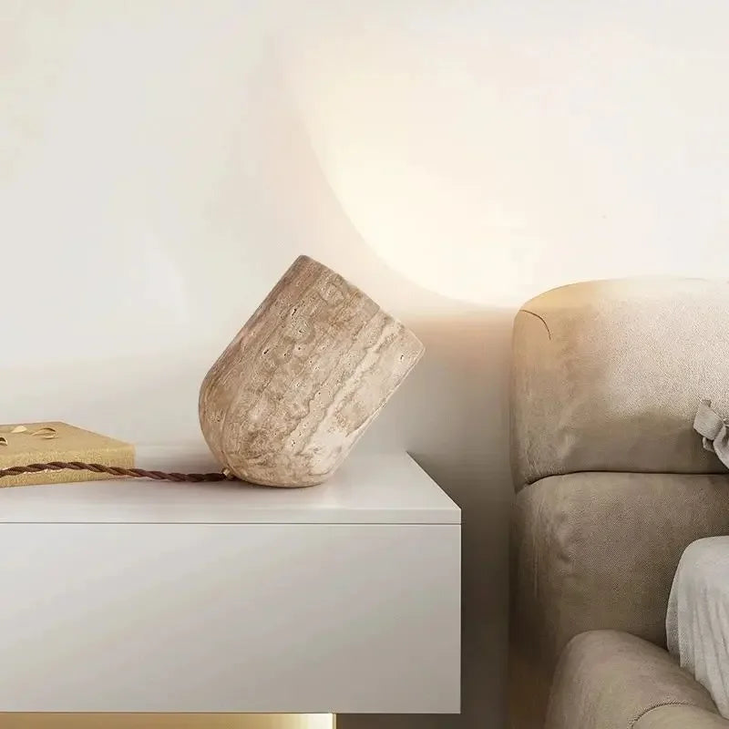 Natural grounded elegance for modern interiors with the Stone Spotlight Table Lamp, carved travertine form casting soft ambient glow beside a contemporary sofa, by Domus Collective