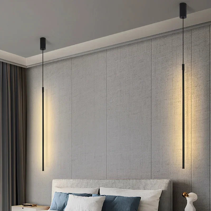 Two Paired black elongated pendants creating layered symmetrical ambient lighting above a contemporary Australian bed,the Streamline Shine Suspension Light,by Domus Collective Steel the Show collection.