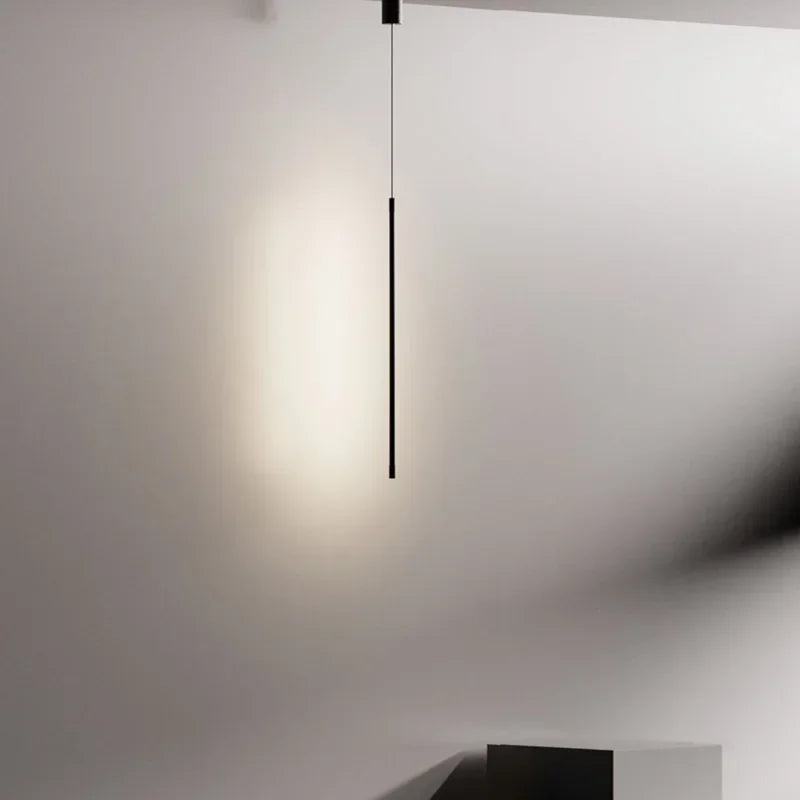 Architectural black linear form casting a luminous soft illumination against a stark minimalist wall ,the Streamline Shine Suspension Light as a sculptural statement for elevated Australian spaces,by Domus Collective curated collection.