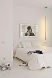 Streamline Shine Suspension Light in brass casting soft ambient glow beside monochrome art in a pristine minimalist Australian bedroom,by Domus Collective curated collection.