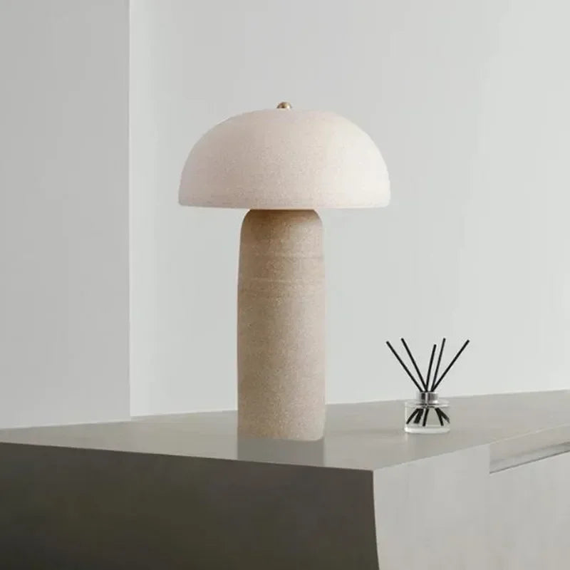 Sculptural Terra Mushroom Table Lamp in warm beige ceramic finish, textured cylindrical base supporting a curved dome shade for ambient illumination, by Domus Collective.