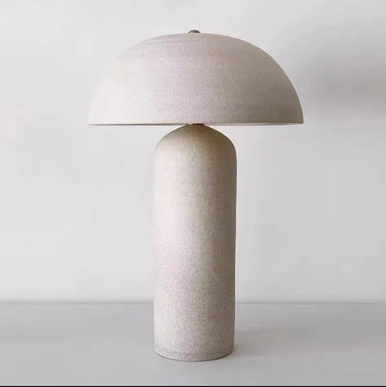 Full studio view of the Terra Mushroom Table Lamp in speckled cream ceramic, organic mushroom silhouette with rounded dome shade and tapered base creating calming natural presence, by Domus Collective.
