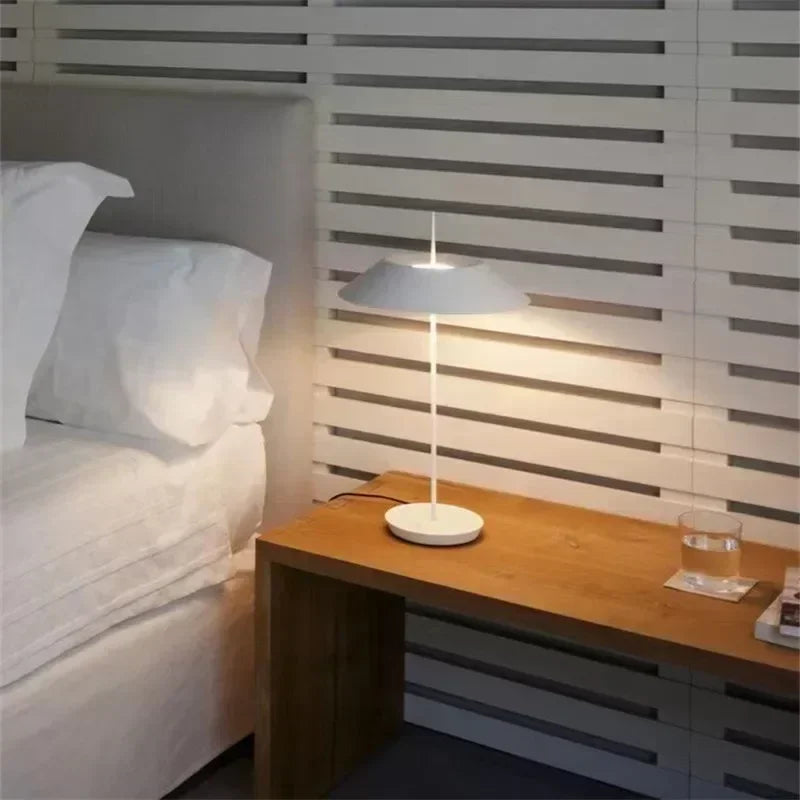 Matte white Toothpick Balance Table Lamp as bedside lighting in a modern bedroom with slatted wall detail, serene ambient glow by Domus Collective.