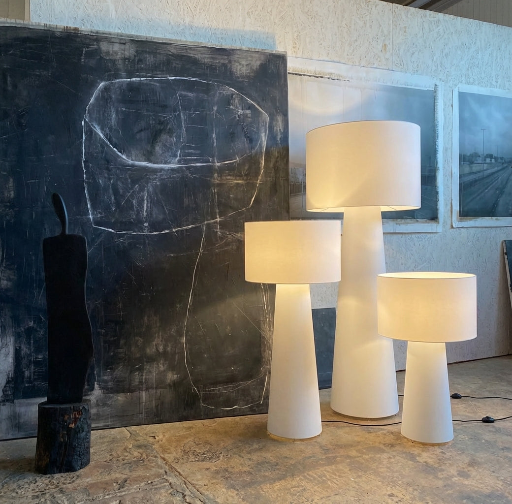 Three Tower Glow Floor Lamps of different heights in a room with an abstract painting and a modern sculpture. All from Domus Collective.